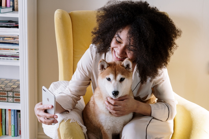 Frauchen mit Hund und Smartphone