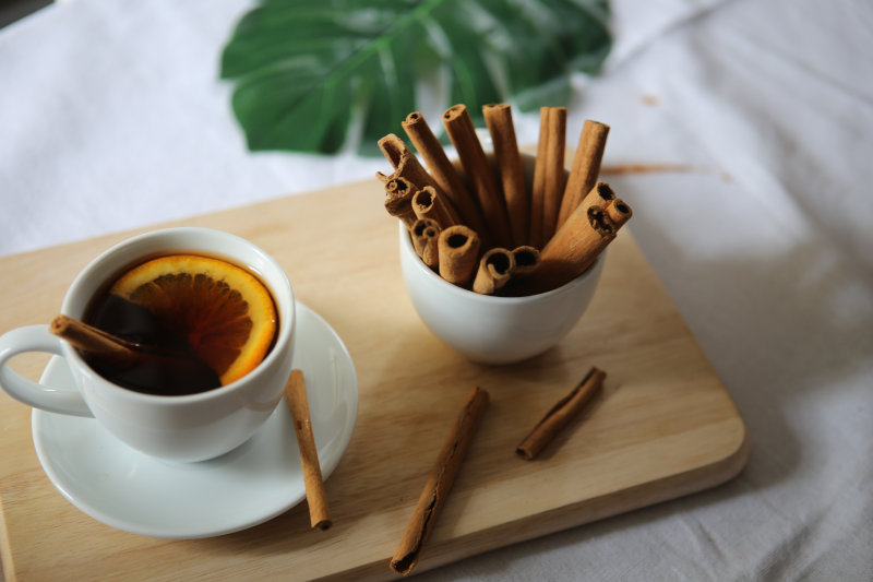 Zimtstangen und Tee auf einem Holzbrett